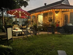 une terrasse avec des chaises, une table et un parasol dans l'établissement Bywater Home, Parking and Pet Friendly Retreat, à La Nouvelle-Orléans
