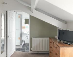 a living room with a television and a dresser at Lingmoor in Windermere