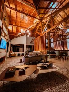 uma grande sala de estar com um grande tecto de madeira em POUSADA GRESSONEY MOUNTAIN em Monte Verde