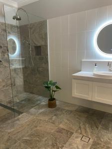 a bathroom with a shower and a sink and a mirror at Bloomfield Manor in Bowral