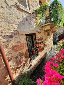 a stone building with a window with flowers on it at Una Rosa sul Mincio in Valeggio sul Mincio