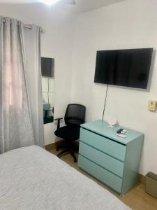 1 dormitorio con 1 cama, vestidor azul y silla en Casa con Parqueo Privado, Patio y Jacuzzi., en Santo Domingo