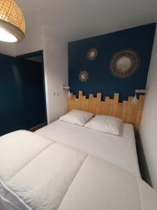 - une chambre avec 2 lits blancs et un mur bleu dans l'établissement La Baie L’Etoile, Apt 4 pers, bord de mer, parking privé, Fort Mahon Plage, à Fort-Mahon-Plage