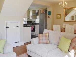 ein Wohnzimmer mit einem Sofa und einer Küche in der Unterkunft Rosies Retreat in Whitby