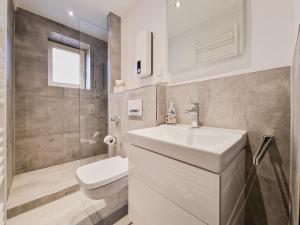 ein Badezimmer mit einem weißen Waschbecken und einem WC in der Unterkunft RAJ Living - City Apartments with 1 or 2 Rooms - 15 Min to Messe DUS and Old Town DUS in Düsseldorf