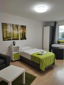 Un dormitorio con una cama, un sofá y una mesa. en Zimmervermietung38 - Nebel, en Salzgitter