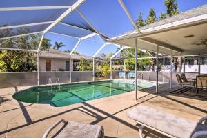 a swimming pool in a house with an umbrella at Breezy Marco Island Home with Pool - Walk to Beach! in Marco Island