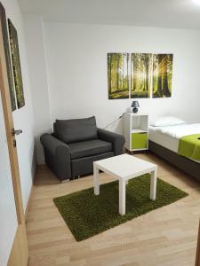 uma sala de estar com uma cama, um sofá e uma mesa em Zimmervermietung38 - Nebel em Salzgitter