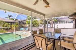 a patio with a table and chairs and a swimming pool at Breezy Marco Island Home with Pool - Walk to Beach! in Marco Island