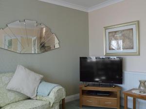 sala de estar con TV de pantalla plana y sofá en The Annexe en Clacton-on-Sea