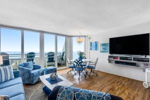 een woonkamer met een grote televisie en een tafel met stoelen bij Pyramid VI in Ocean City