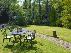 a table and chairs in a garden with a table and chairs at Ivy Cottage in Sandhurst