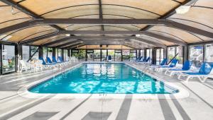 una piscina con sillas azules y un gran techo en Wellington Resort, en Newport