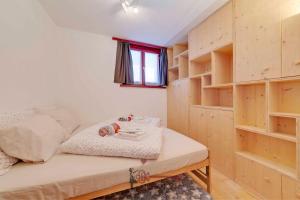 Habitación pequeña con cama y estanterías de madera en Chalet 5 stars in San Bernardino, SKI SLOPES AND HIKING, Fireplace, 4 Snowtubes Free, Wi-Fi Free, for 8 persons, Wonderful in all seasons -By EasyLife Swiss en San Bernardino