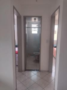 an empty bathroom with a toilet and a doorway at Apartamento bem localizado in São José