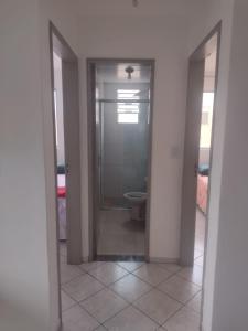 an empty bathroom with a toilet and a doorway at Apartamento bem localizado in São José +10 photos