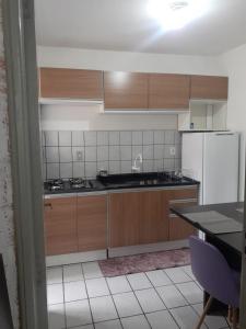 a kitchen with wooden cabinets and a white refrigerator at Apartamento bem localizado in São José