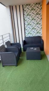 2 sillas y una mesa en una habitación con alfombra verde en La Petite Escapade, en Seynod