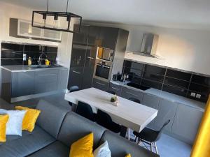 salon z kanapą i stołem w kuchni w obiekcie La Petite Escapade w mieście Seynod