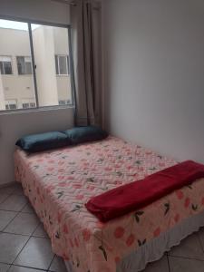 a bed in a bedroom with a window at Apartamento bem localizado in São José