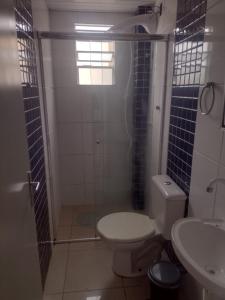 a bathroom with a shower and a toilet and a sink at Apartamento bem localizado in São José