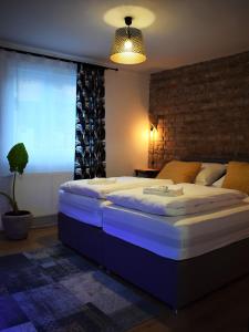 a large bed in a room with a brick wall at Green Garden Station in Zagreb