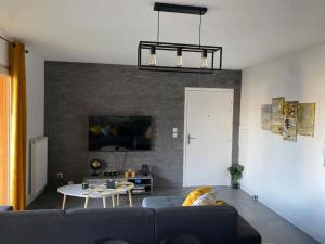 salon z kanapą i stołem w obiekcie La Petite Escapade w mieście Seynod