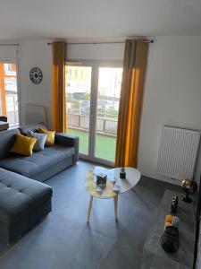 salon z kanapą i stołem w obiekcie La Petite Escapade w mieście Seynod