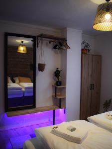 a room with two beds and a mirror with purple lights at Green Garden Station in Zagreb