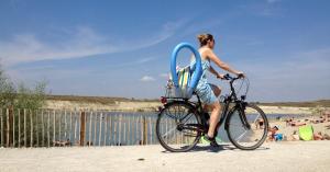 Un homme à vélo à la plage avec une planche de surf à bord dans l'établissement Ferienzimmer Seepark, à Vienne