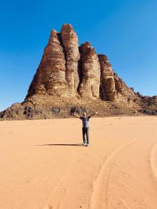 a man standing in the desert in front of rock formations at Wadi rum desert sky in Wadi Rum