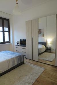 - une chambre avec un lit et une commode avec un miroir dans l'établissement Incantevoli Appartamenti Navigli, à Milan