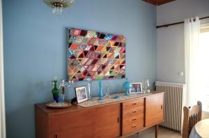 a wooden dresser in a room with a painting on the wall at Mid Century Modern Apartment - Atelier in Olympia