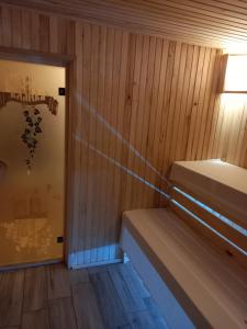 Zimmer mit einer Sauna mit Holzwänden und einer Tür in der Unterkunft Садиба ЯНА in Switjas