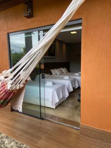 a bedroom with two beds and a glass wall at Pousada Guardiã da Canastra in Vargem Bonita