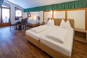 una camera d'albergo con un letto grande e un tavolo di Ferienhotel Fuchs a Söll