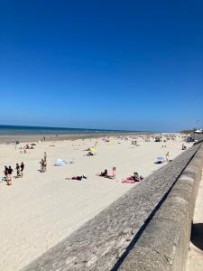 un groupe de personnes sur une plage près de l'océan dans l'établissement La Baie L’Etoile, Apt 4 pers, bord de mer, parking privé, Fort Mahon Plage, à Fort-Mahon-Plage