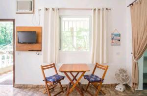 een eetkamer met een tafel en twee stoelen bij Loft Praia Brava - Suíte com Área Gourmet Privativa in Ubatuba +51 foto's