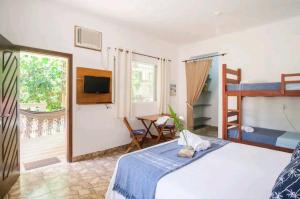 een slaapkamer met een bed en een stapelbed bij Loft Praia Brava - Suíte com Área Gourmet Privativa in Ubatuba