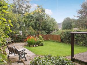 a park bench in a garden with a lawn at Wee Ben in Bridge of Tilt