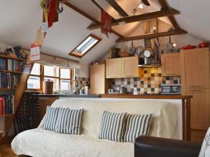 a living room with a couch and a kitchen at Stoker Loft in West Mersea