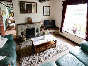 a living room with a couch and a fireplace at The Cottage in Cloughton