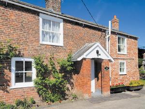 a red brick house with a white door at Salters Cottage - E5045 in Wainfleet All Saints