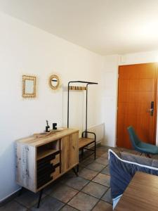 ein Wohnzimmer mit einem Holzschrank und einem Stuhl in der Unterkunft T3 au pied des Pyrénées in Pointis-de-Rivière