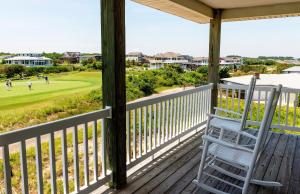 a rocking chair on a porch with a golf course at KH5007- Fore Sea Suns in Kitty Hawk