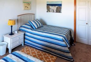a small bedroom with a bed and a night stand at KH5007- Fore Sea Suns in Kitty Hawk +38 photos