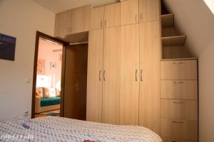 1 dormitorio con armarios de madera y 1 cama en Sunny 412 apartment en Podgorica