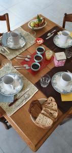 een houten tafel met brood en kopjes en borden erop bij L'Oseraie du Quercy in Calvignac