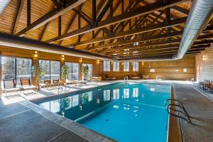 a large swimming pool in a building with a wooden ceiling at Purgatory Perch in Durango Mountain Resort
