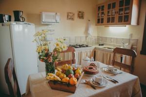 a table in a kitchen with a bowl of fruit at Hospedaria de Alice in Tiradentes +22 photos
